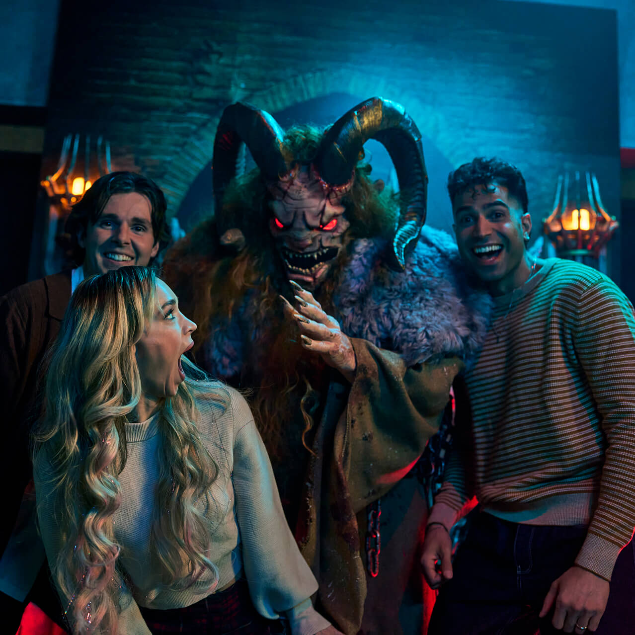 A group of three adults pose for a photo with Krampus in front of a stone wall as Krampus reaches to grab a screaming woman in front.