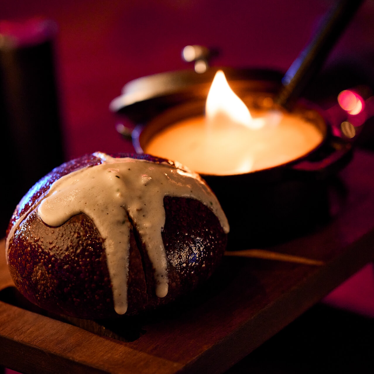 Round bread rolls topped with melted cheese sauce served with a pot of molten smoked paprika cheese.
