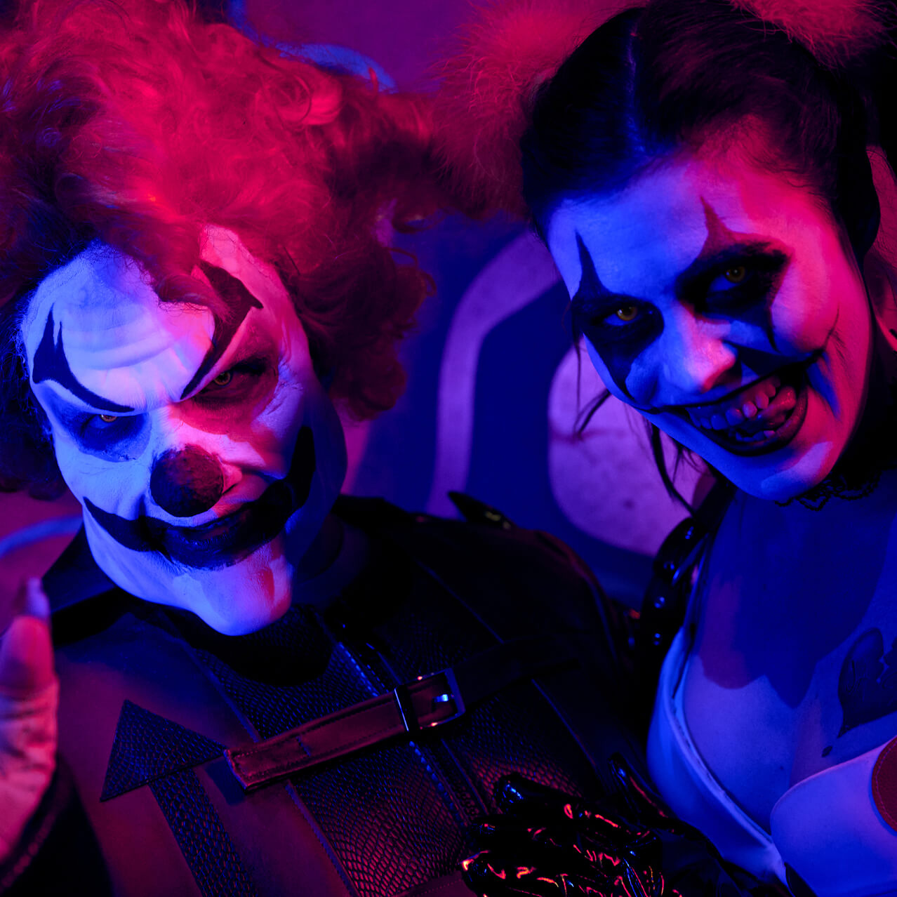 Jack and Chance in sinister clown makeup under red and blue lighting.