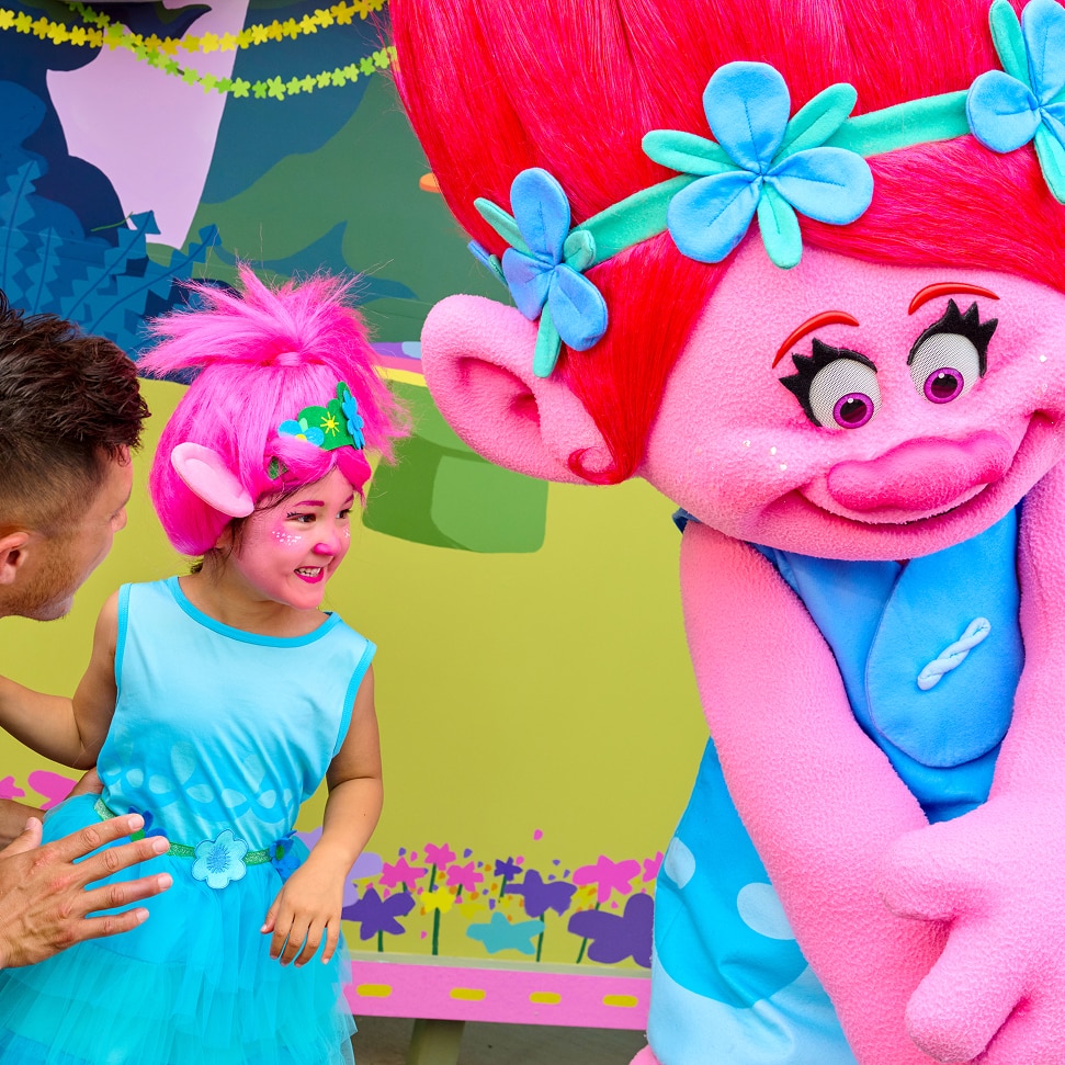 Examples of colorful Trolls-inspired face makeup featured with the Become Trollified logo.
