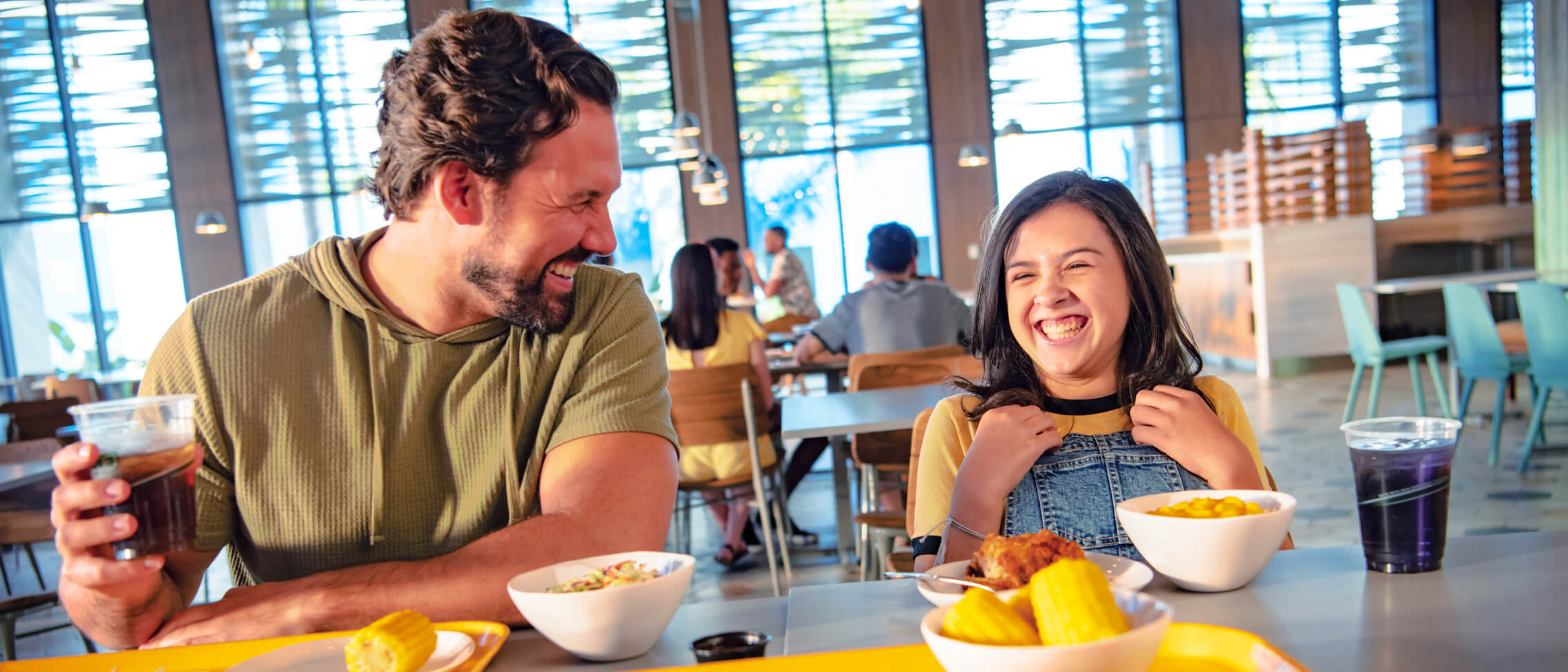 A father and daughter enjoy a meal at Pier 8 Market in Universal Endless Summer Resort - Dockside Inn and Suites.