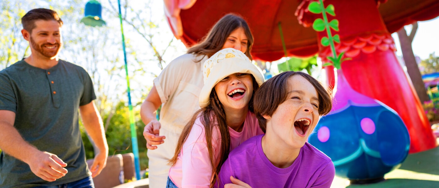 A family laughing while exiting a kid-appropriate ride.