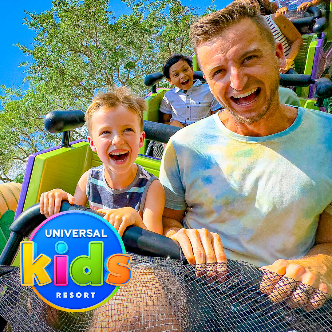 Un hombre y un niño ríen en una montaña rusa familiar en Universal Kids Resort; el logotipo de Universal Kids Resort aparece en la esquina.