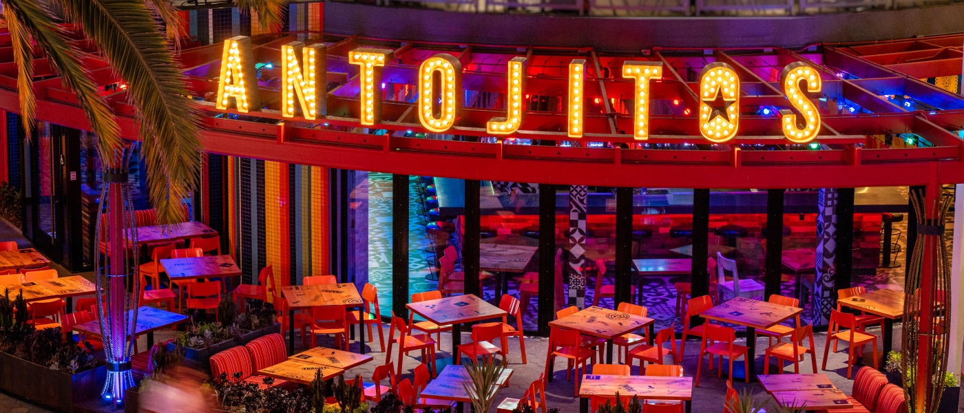 The front entrance of Antojitos Cocina Mexicana lit up at night.