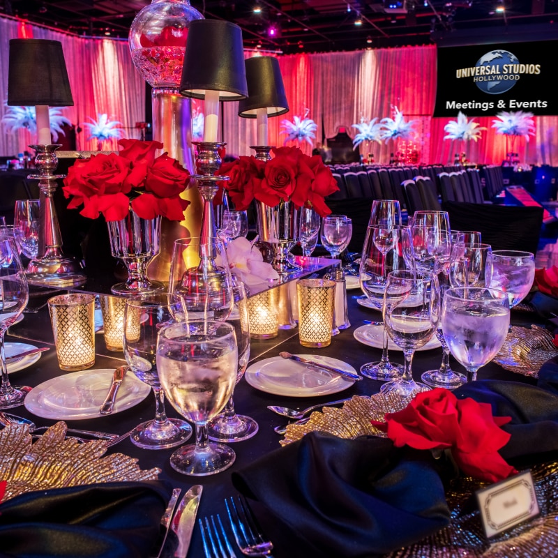 Tables decorated with red and black decor for an event.