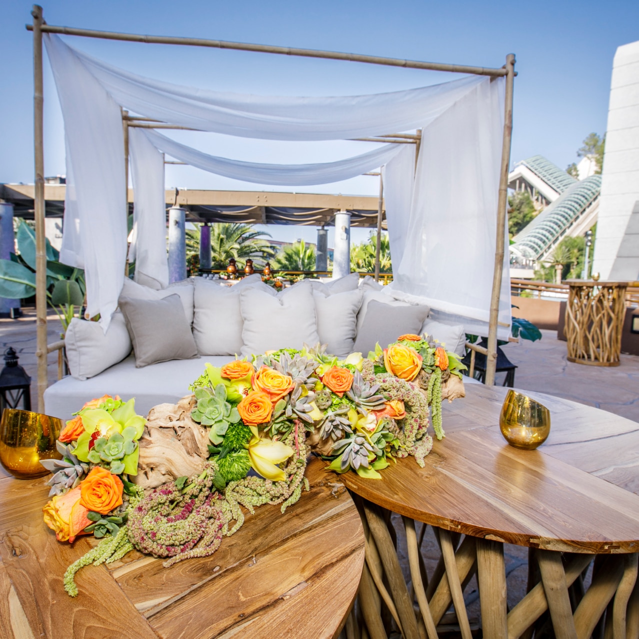 A white couch and wooden table with a floral arrangement on top.