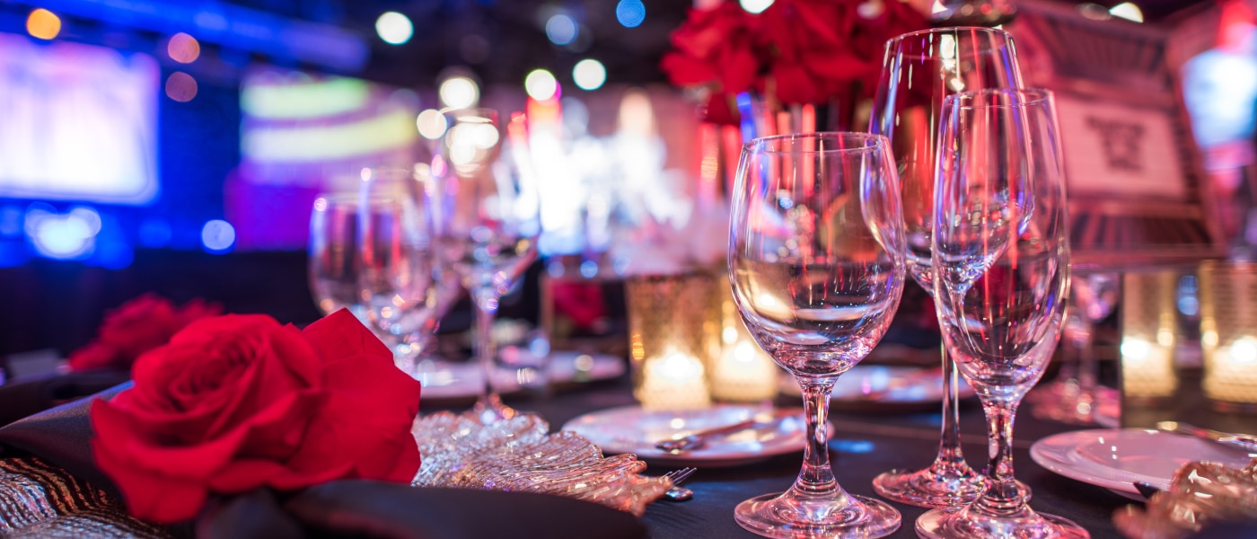 A close up of a table decorated with red and black decor for an event.