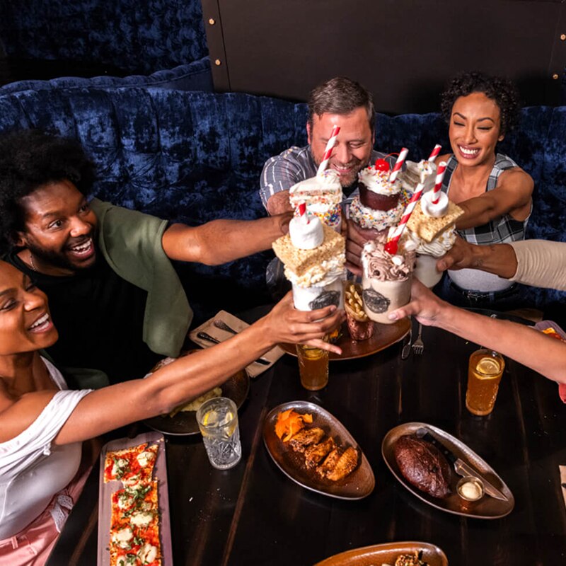 A group of people celebrating together with food and drinks