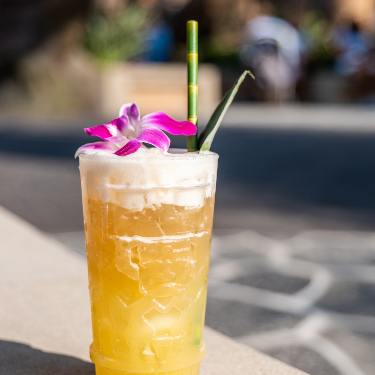 A tropical tiki cocktail with a purple orchid on top.