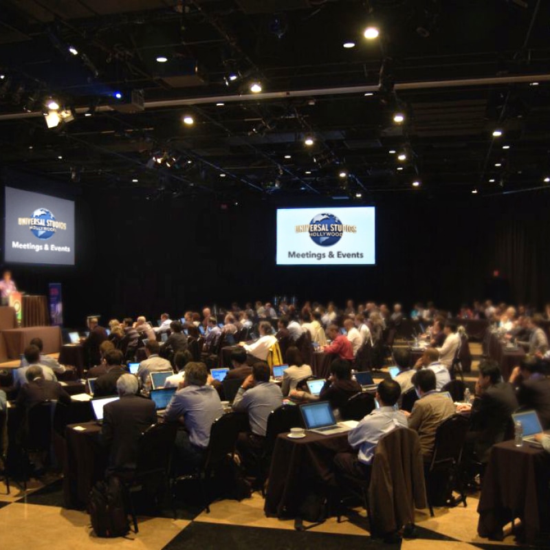 Dozens of people sitting in an event space during a presentation at Universal Studios Hollywood.