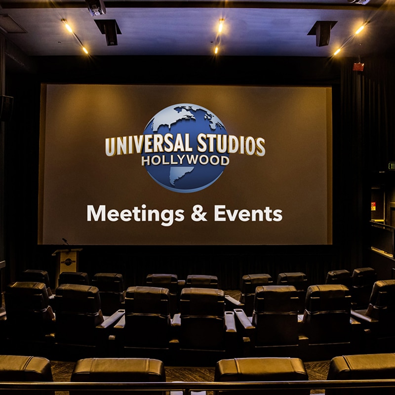 A view from theater seating, facing the screen, showing Universal Studios Hollywood Meetings and Events on the screen