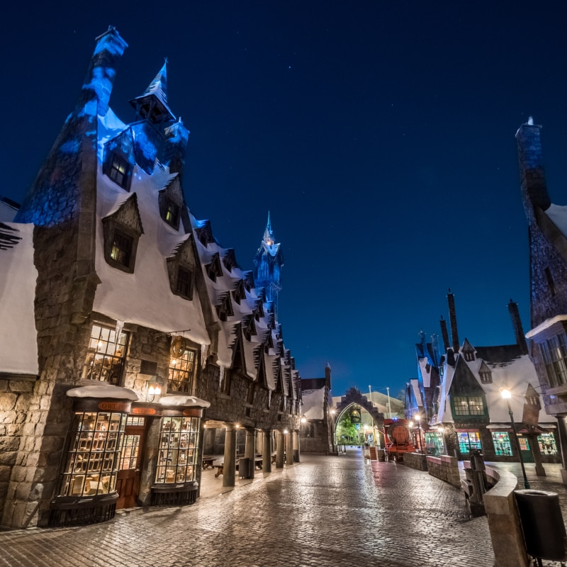 A nighttime view of Hogsmeade™ in The Wizarding World of Harry Potter.