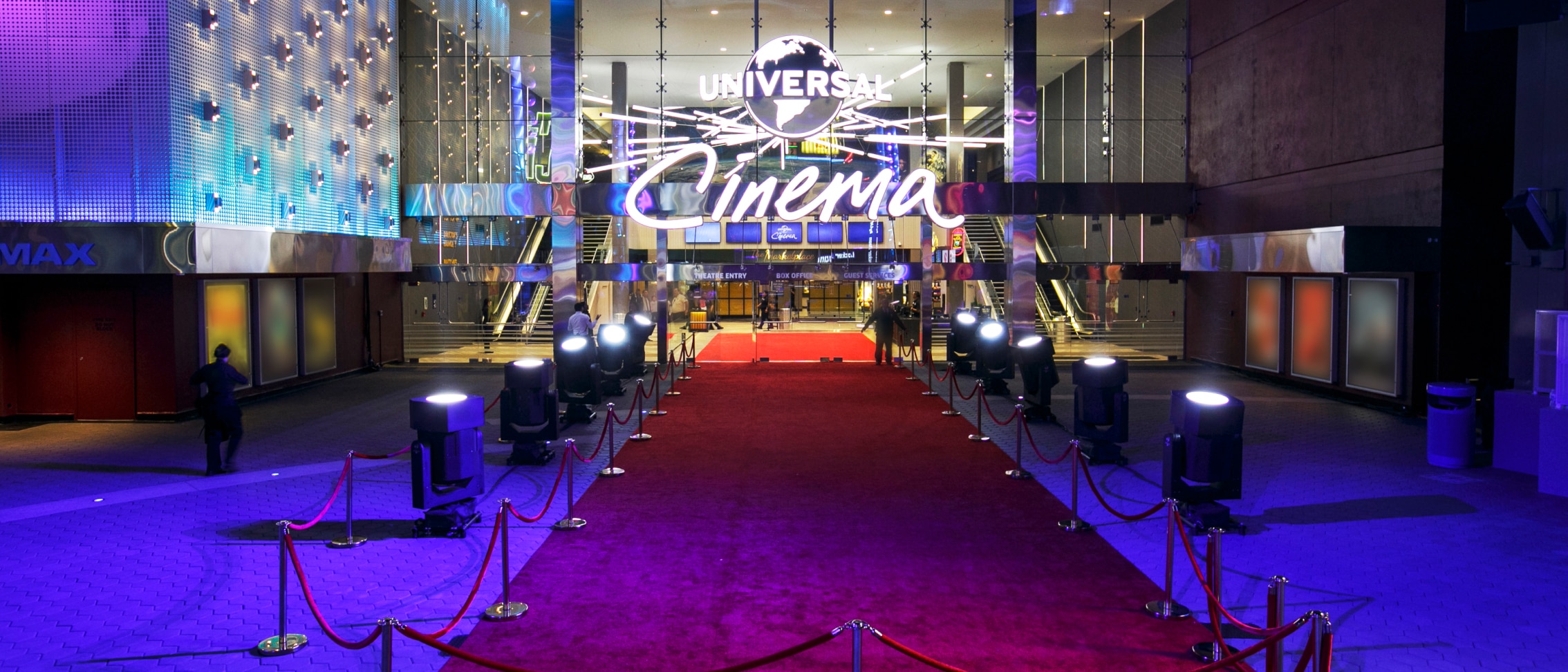 Main theater entrance with large Universal Cinema logo and name in bright lights.