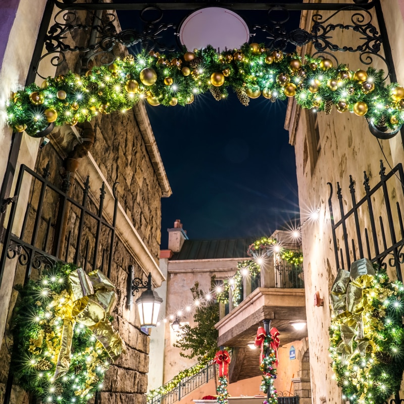 A garland archway wrapped in white lights hanging above the street for the holidays.