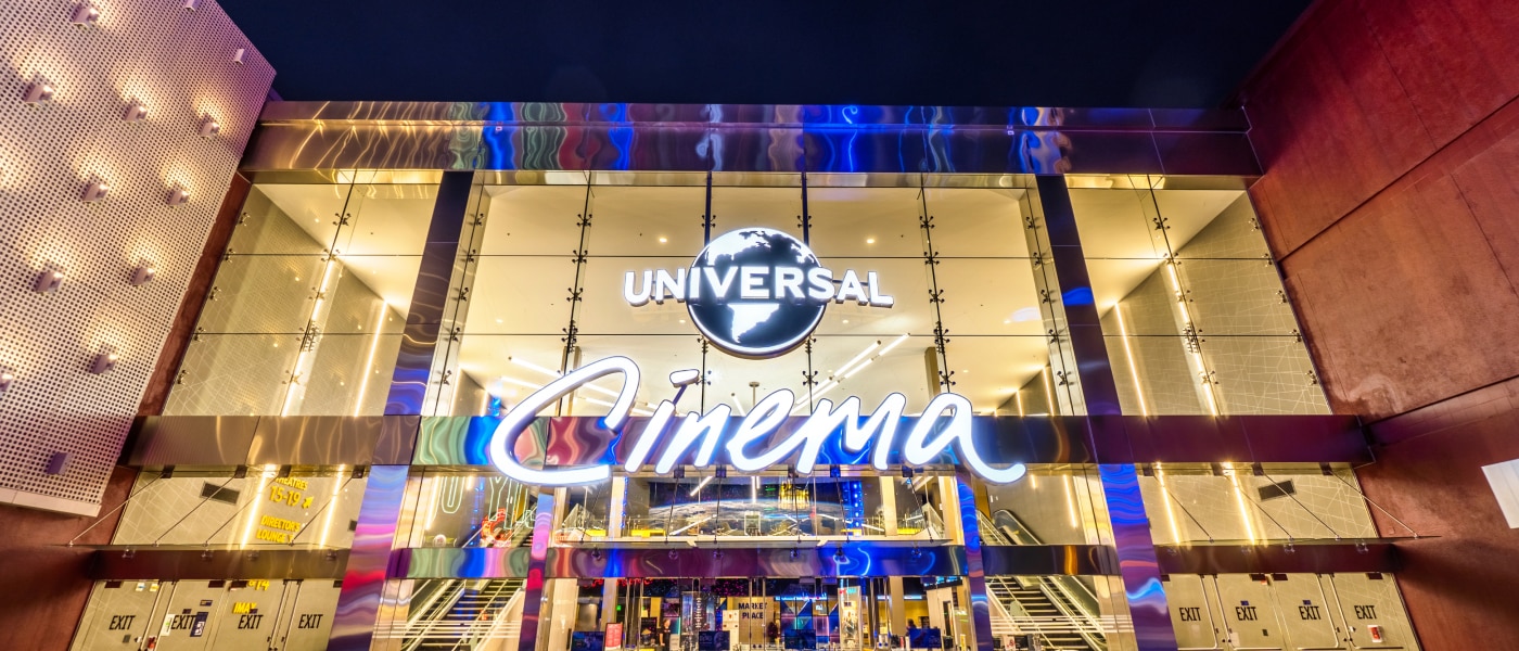 The front entrance of Universal Cinema lit up at night.