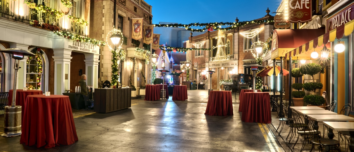 Tables with red tablecloths and candles in the middle of Streets of the World at Universal Studios Hollywood.