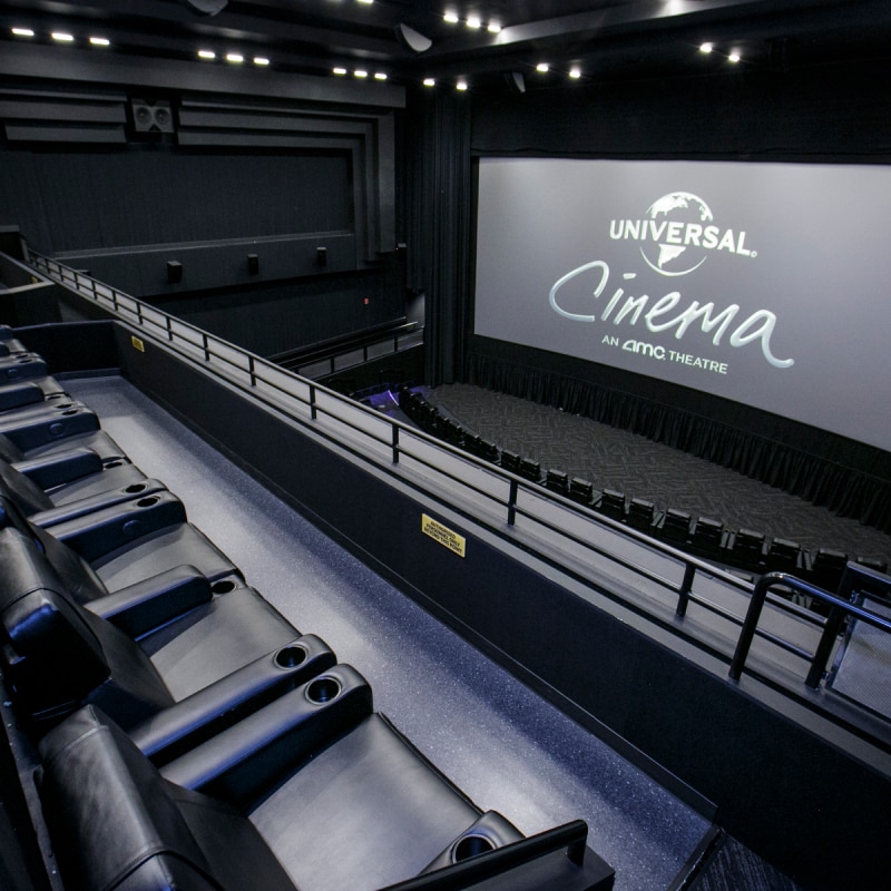 An empty row of seats inside of a theater in Universal Cinema.