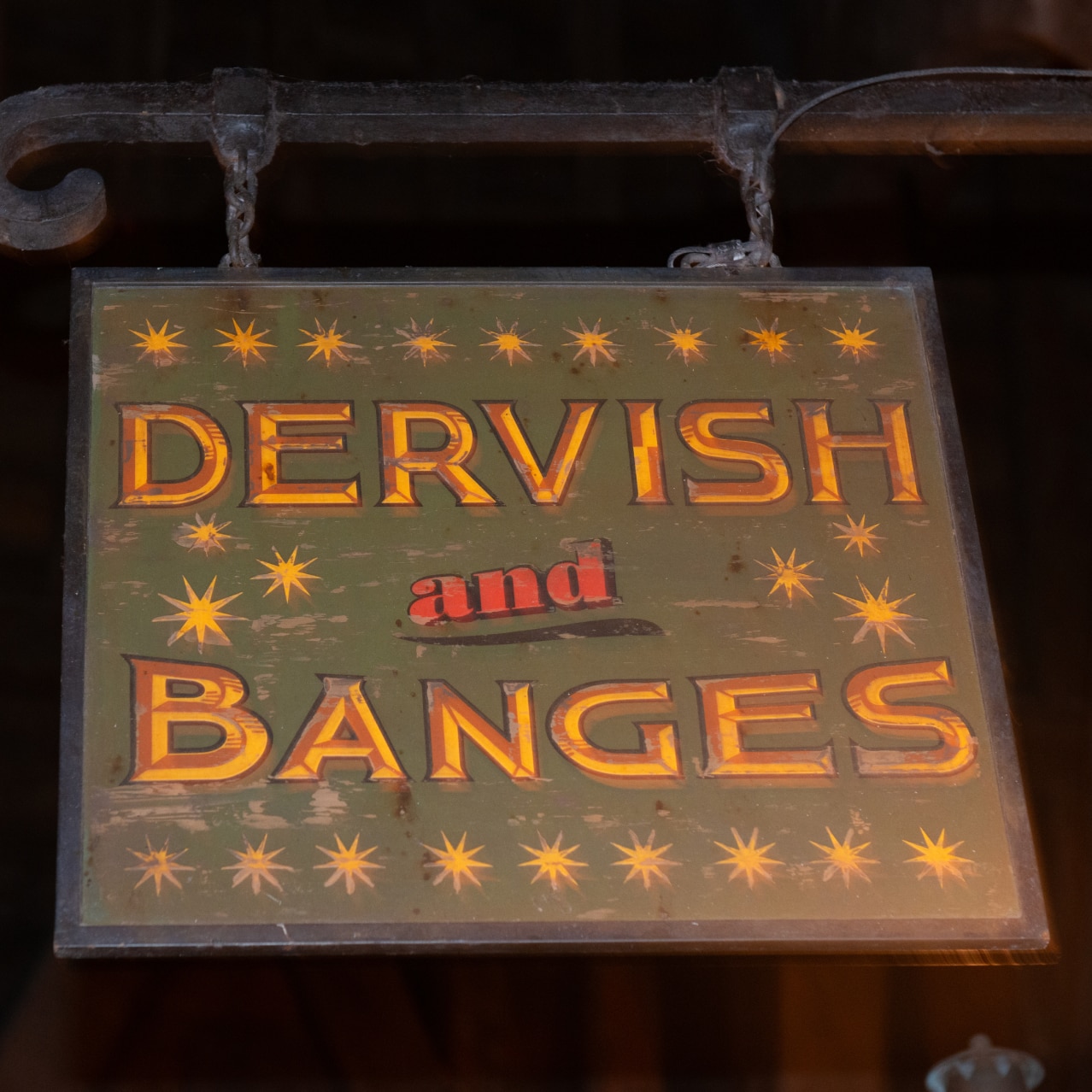 A wooden sign hanging that says Dervish and Banges™.