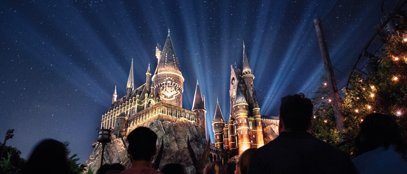 Hogwarts Castle with spotlights shining behind it at The Wizarding World of Harry Potter.