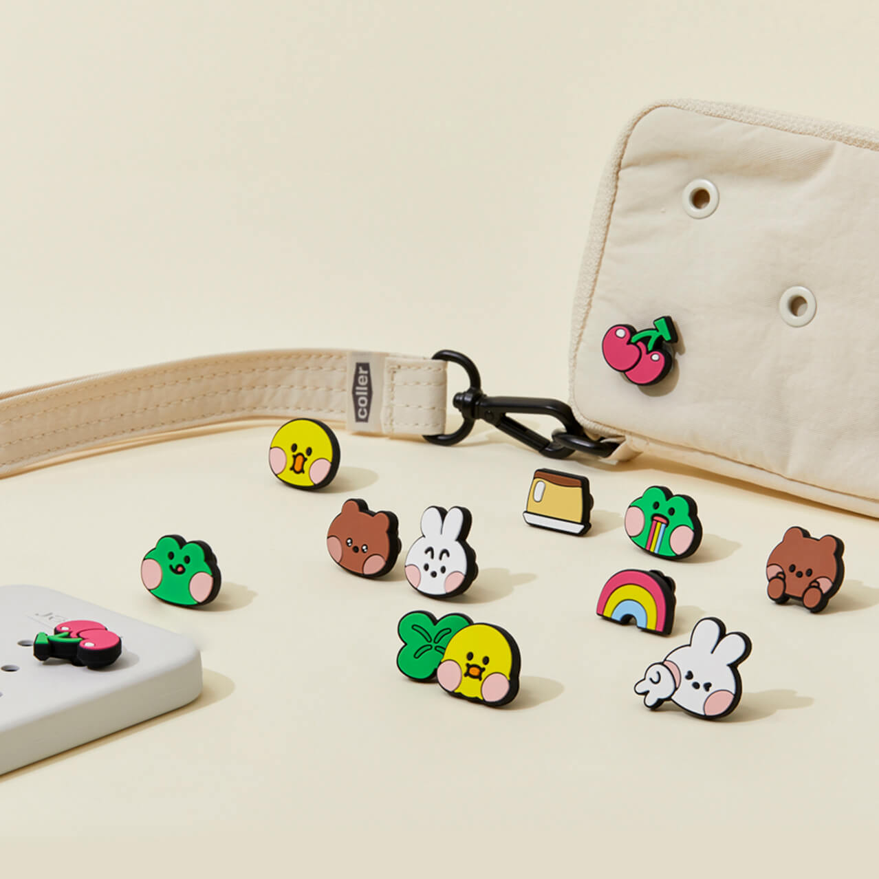An assortment of LINE FRIENDS charms next to a mobile device and a wristlet, each decorated with charms.