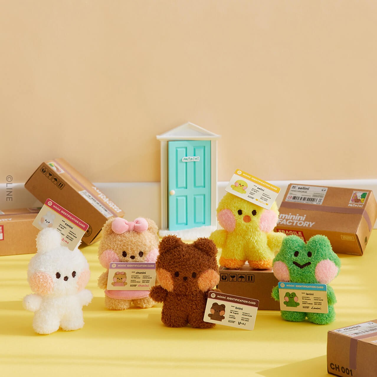 Five minini plushies standing in front of minini Factory boxes with their minini ID cards.