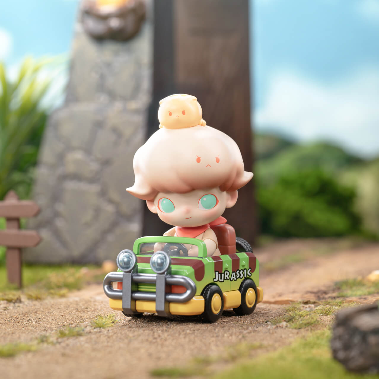 The toy doll DIMOO sitting in a toy Jeep with the word ‘Jurassic’ on the door.