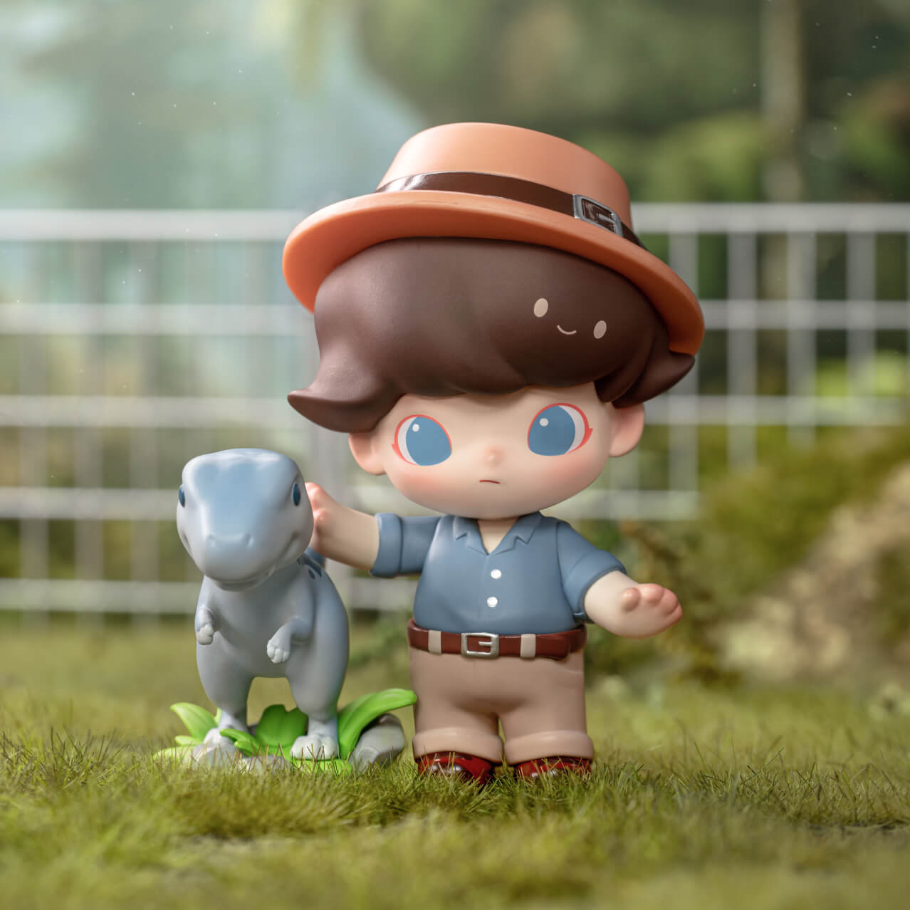 The toy doll DIMOO wearing a blue shirt, khakis and fedora and petting a small gray dinosaur.
