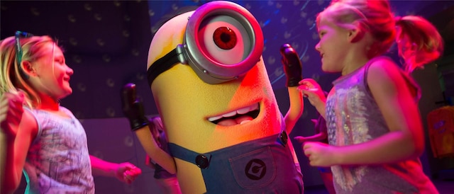 Two young girls dance and play with a Minion. Two young girls dance and play with a Minion.