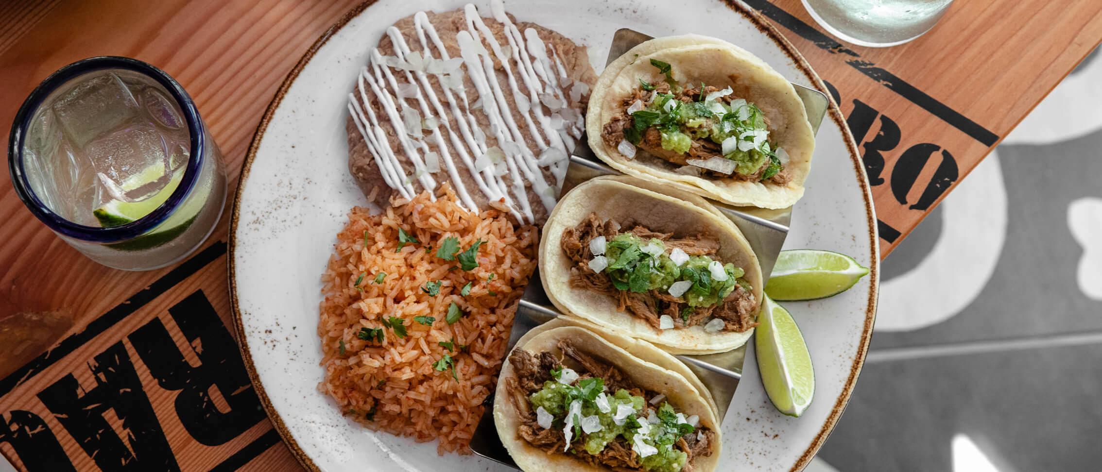 A plate of three soft tacos with rice and refried beans at Antojitos Cocina Mexicana.