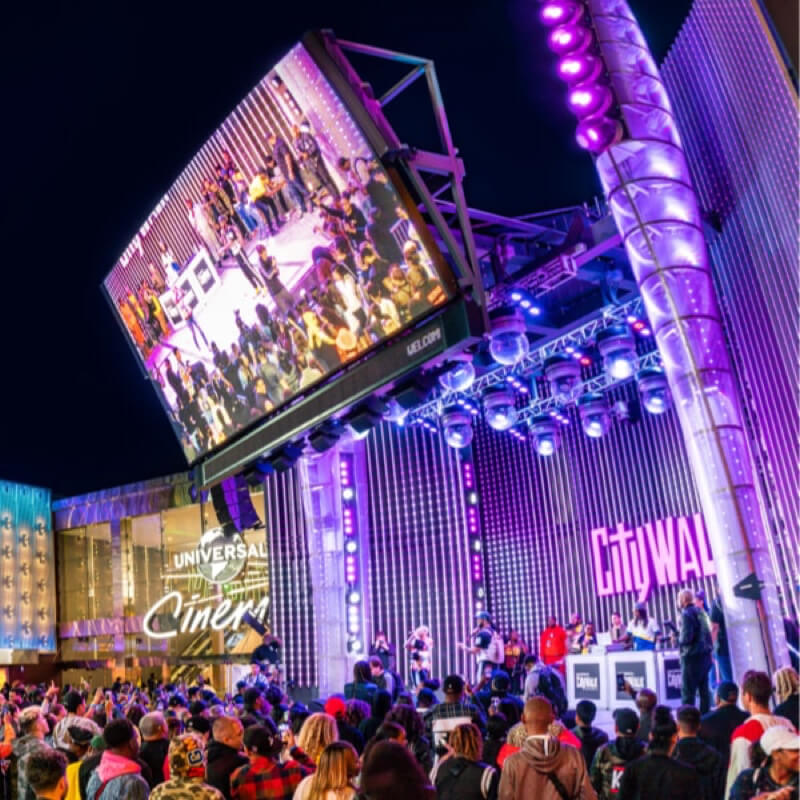 A large crowd gathers outside for a performance at the 5 Towers Stage at CityWalk Hollywood.