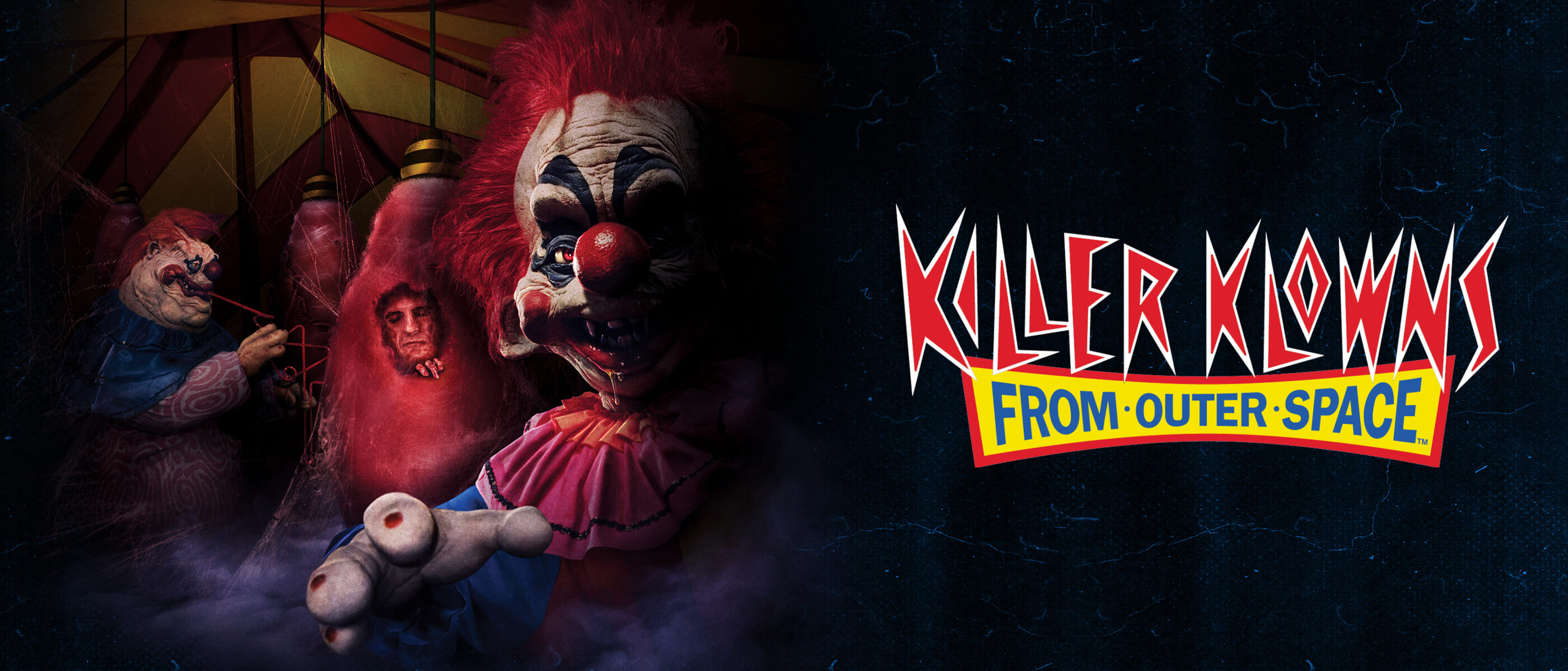 Promotional banner for Killer Klowns from Outer Space featuring eerie clown characters emerging from a dark circus scene.