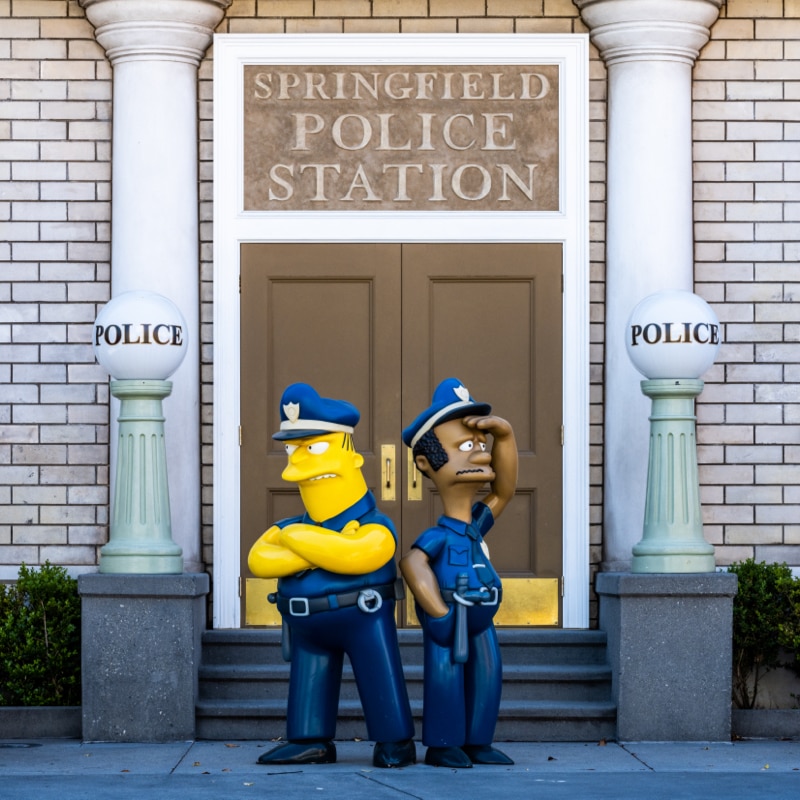Police officers Eddie and Lou keep guard outside of the police station.