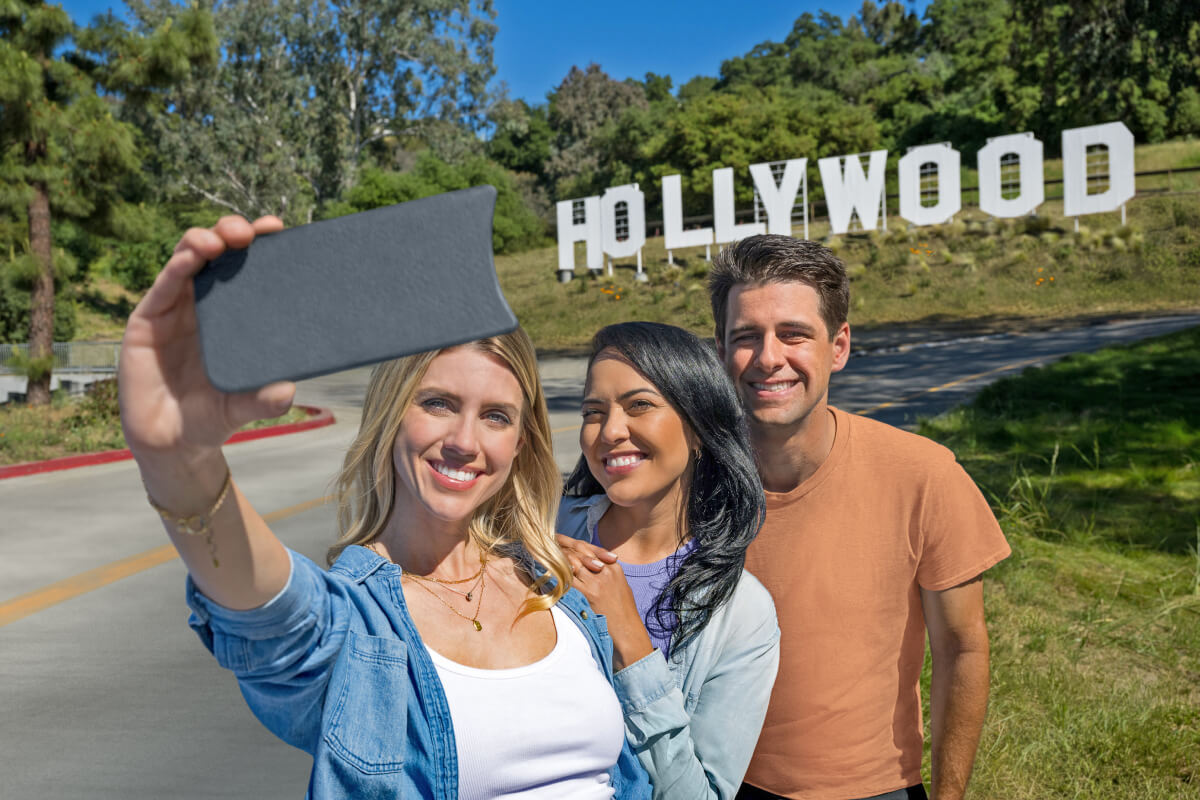 A few friends taking a selfie in front of a scaled replica of one of L.A.'s most famous landmarks, the Hollywood Sign.