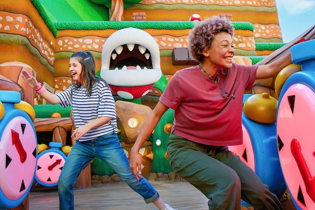 Two friends playing Piranha Plant Nap Mishap with their Power-Up Bands inside SUPER NINTENDO WORLD™ at Universal Studios Hollywood.