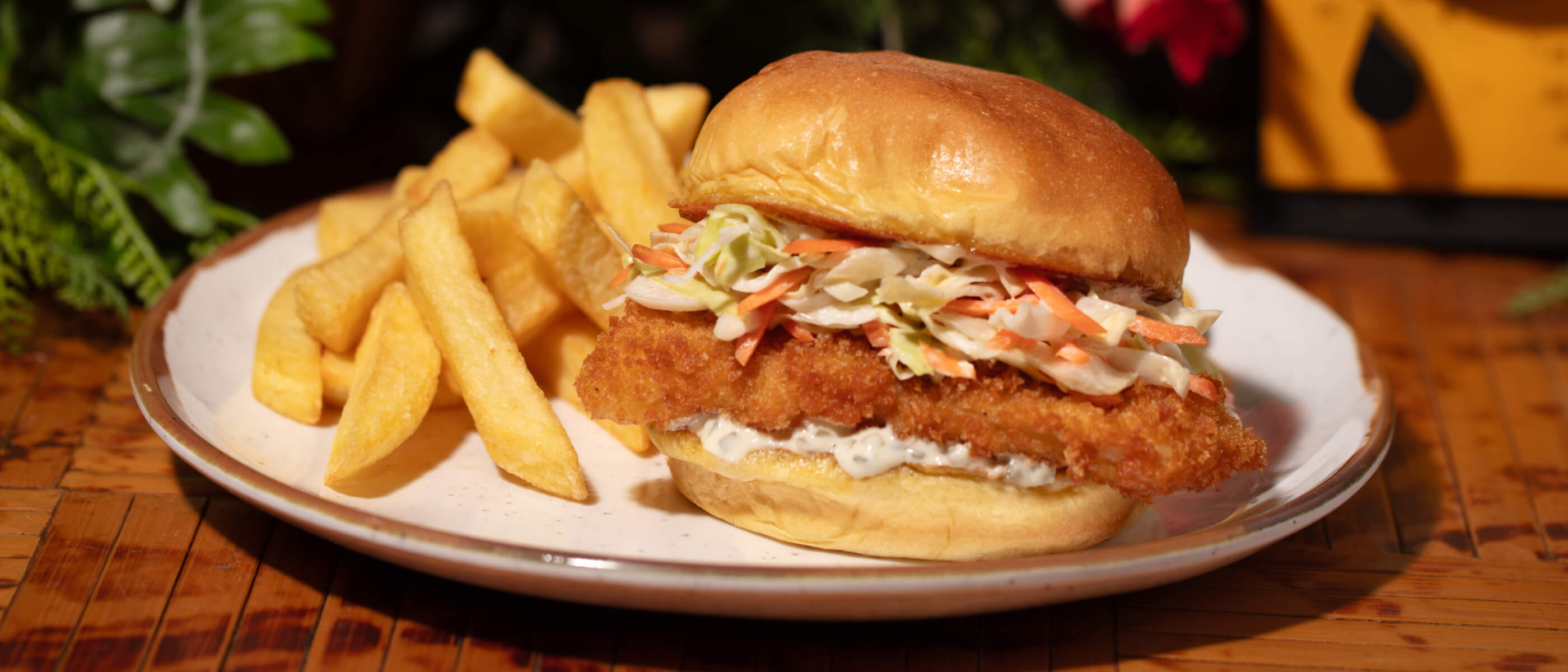 A Jurassic Park themed fried fish sandwich next to a pile of fries, available at Universal Studios Hollywood.