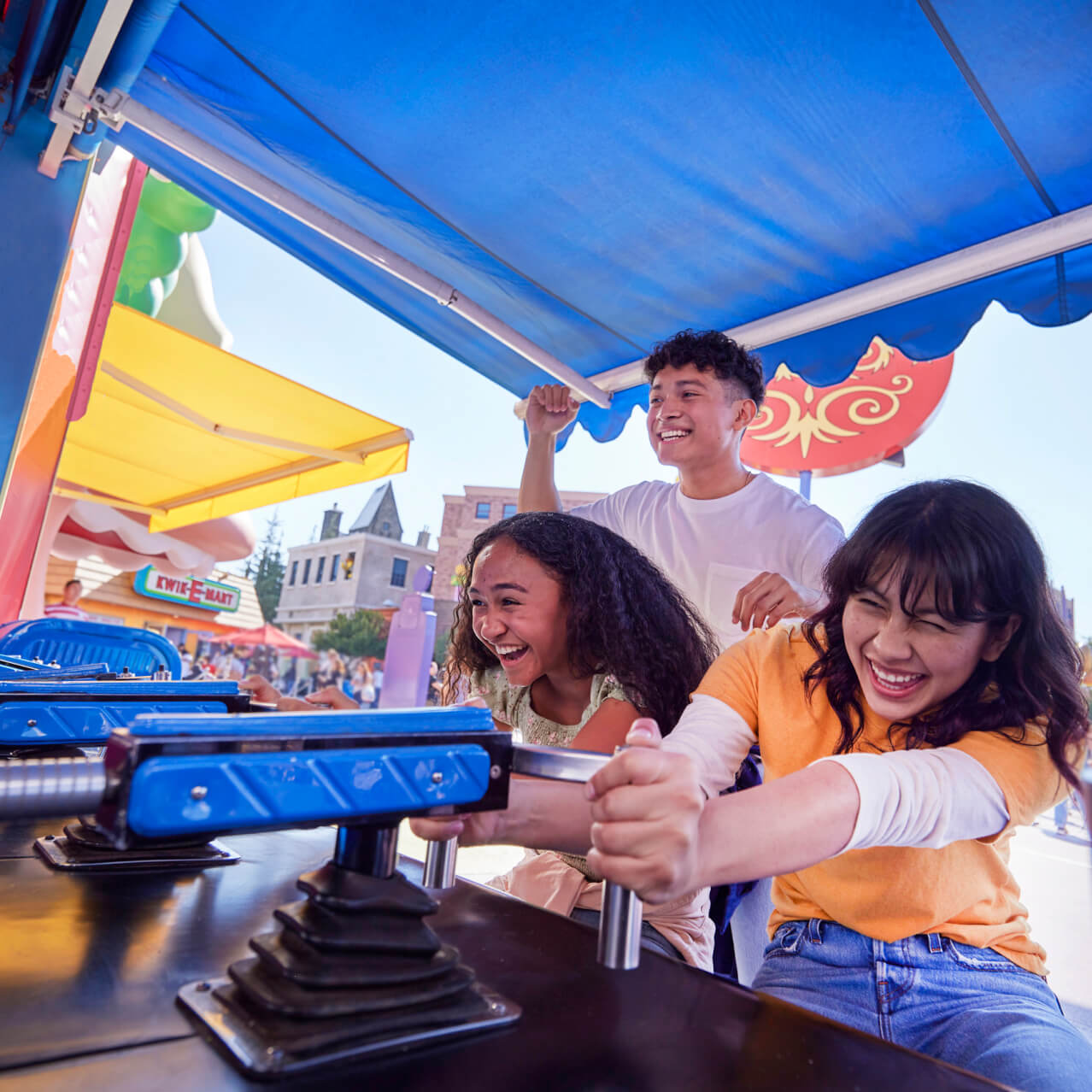 Three guests playing carnival games in Springfield at Universal Studios Hollywood.