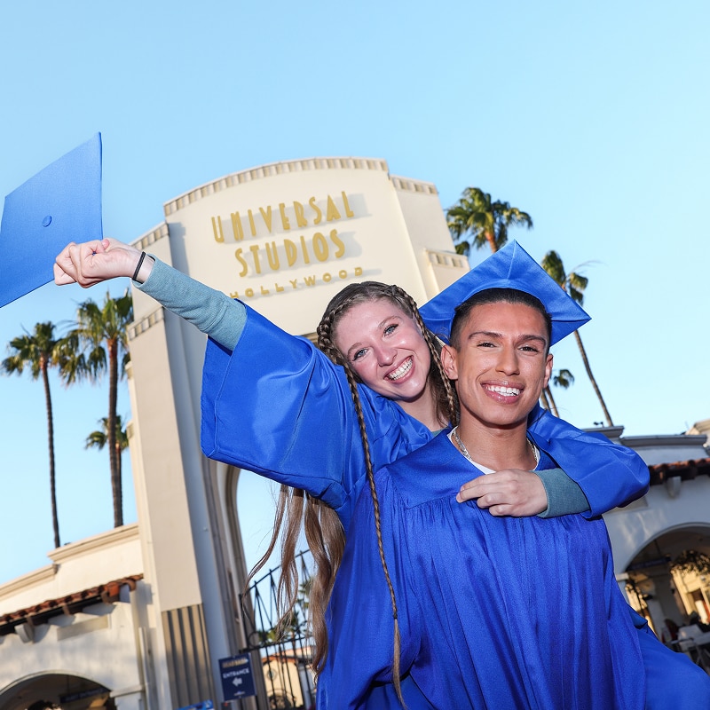 A male and female student celebrating graduation