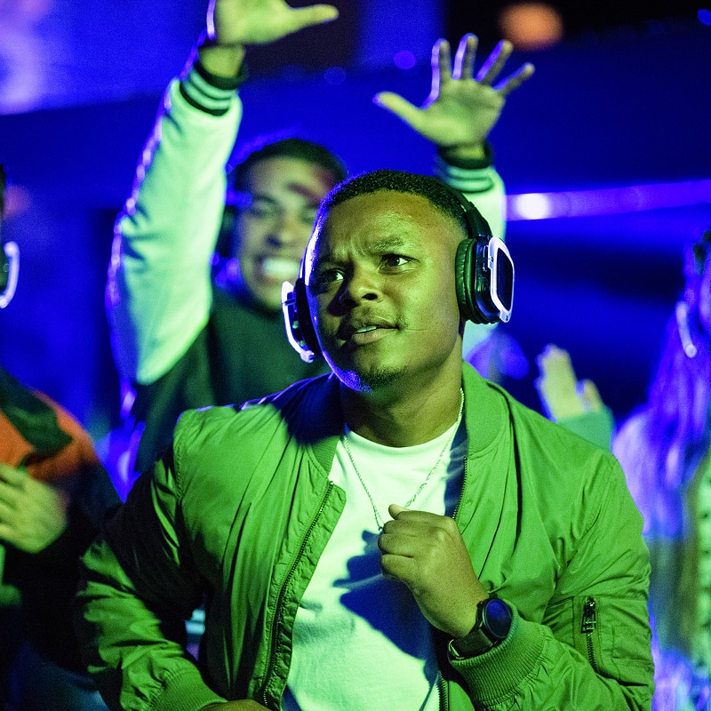A group of individuals listening to music on headphones while dancing