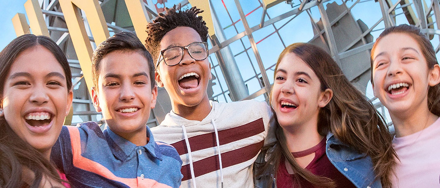 A young friend group smiling in front of the Universal Studios Hollywood globe