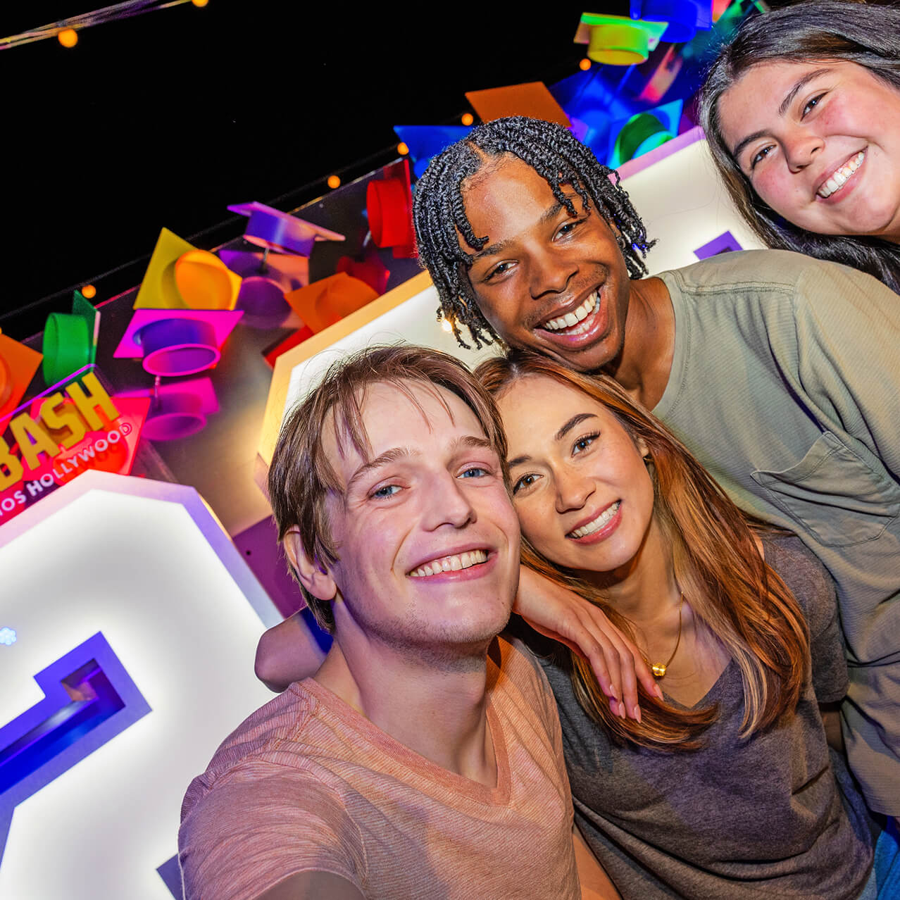 Teenager smiling for the camera in front of the Grad Bash signage