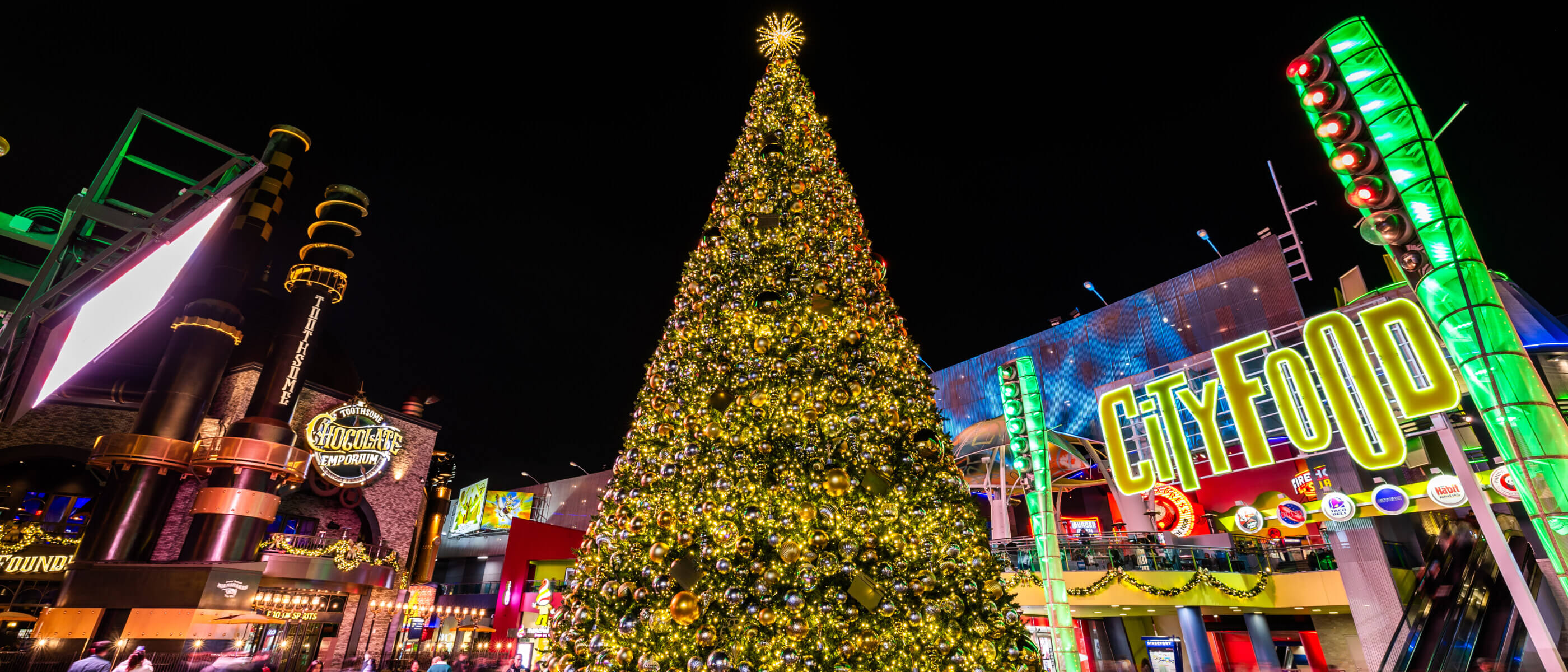 A tall silver and gold Christmas tree at the center of Universal Citywalk Hollywood.