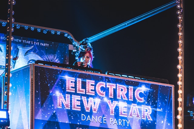 A neon sign reading Electric New Year lights the way to a party area at Universal Studios Hollywood’s Eve event.