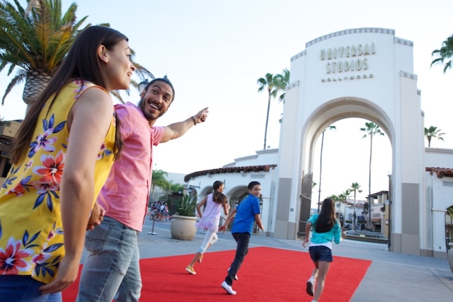 Two parents and their three children on the red carpet at the entrance of the Universal Studios Hollywood park.