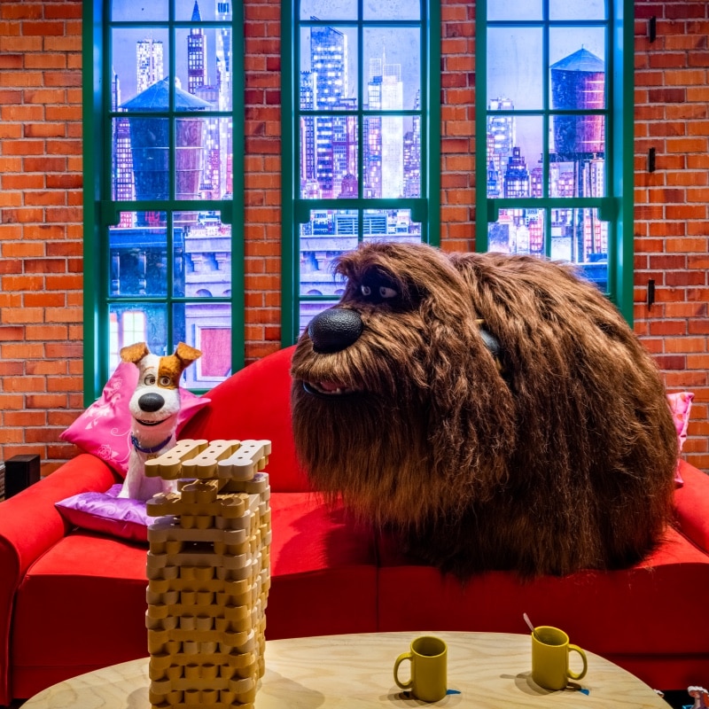 Characters from the Secret Life of Pets pose on couch 