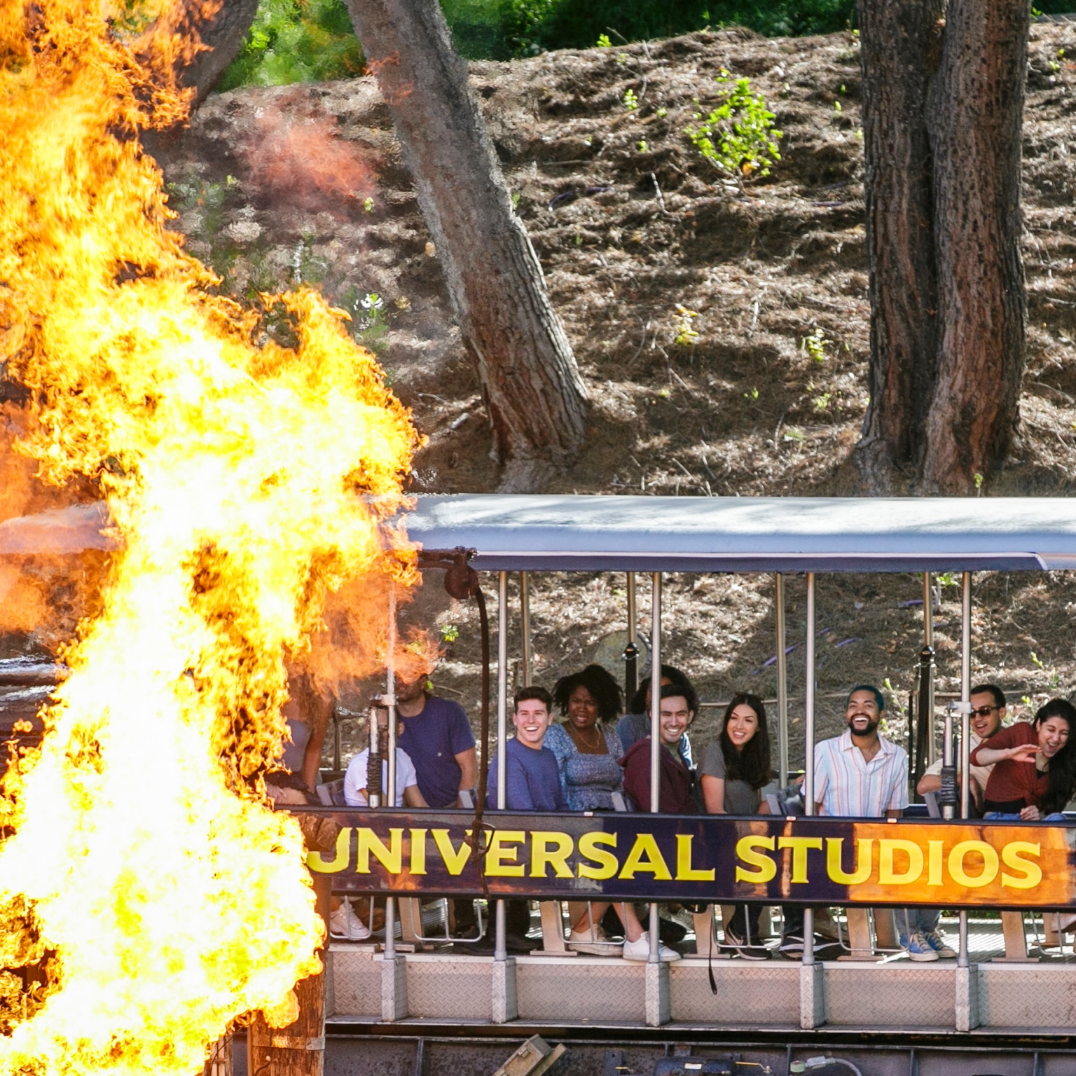 Guests aboard a tram on the Universal Studios Hollywood Studio Tour gaze at a blazing fire from the “Jaws” set.