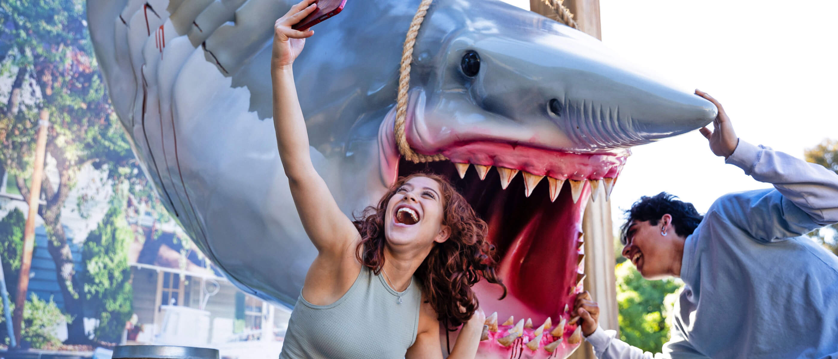 A couple taking a selfie in front of the iconic hanging Jaws.