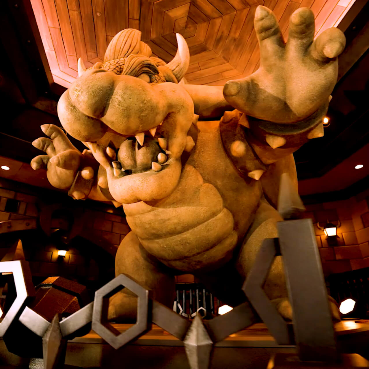 A statue of the snarling Bowser character looms menacingly overhead in the entry area of Bowser’s Castle.