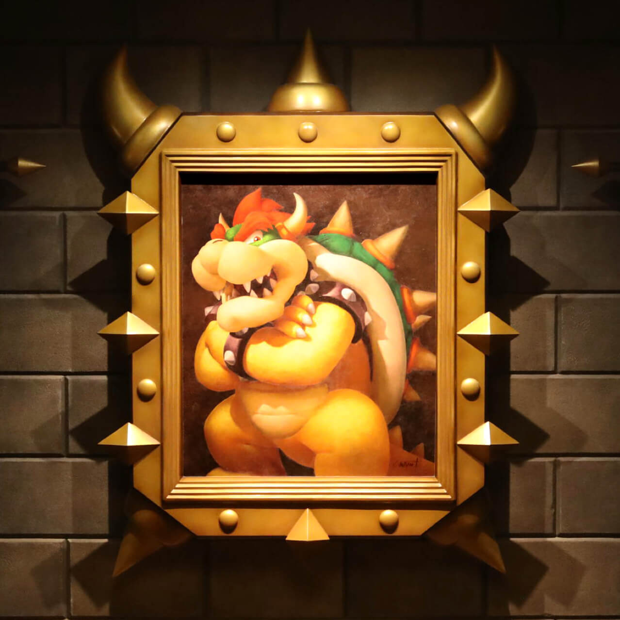 A painted portrait of a cross-armed Bowser in a metallic frame sits against a wall in Bowser’s Castle.
