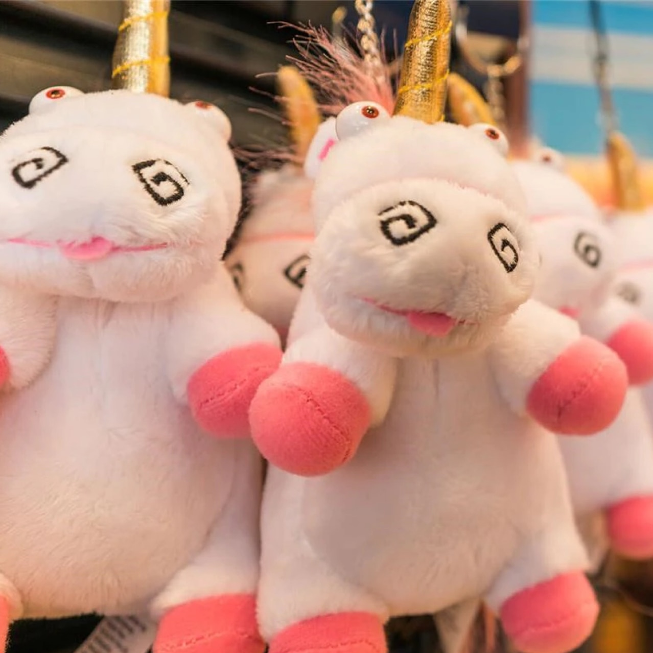 Stuffed pink and white unicorns in a store.