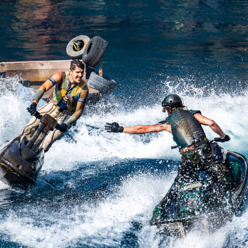Two performers riding on jetskis during the WaterWorld Show at Universal Studios Hollywood.